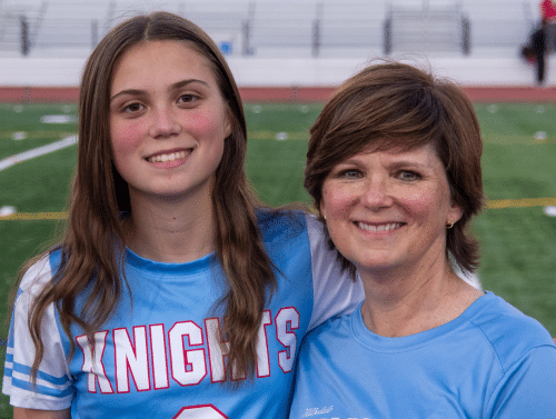 Who We Are: Teen in a Knights jersey and an older woman smile on a sports field.