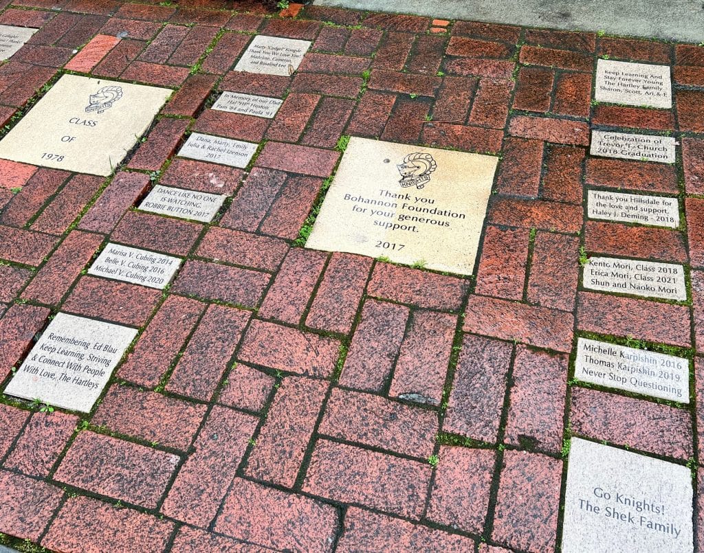 Engraved bricks on a red walkway honor donors and commemorate graduates and families.